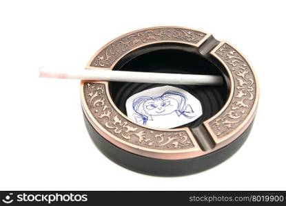 portrait of child and cigarette in ashtray on white background closeup
