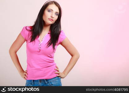 Portrait of childish young woman with headband on her hair. Infantile girl on pink. Longing for childhood. Studio shot.