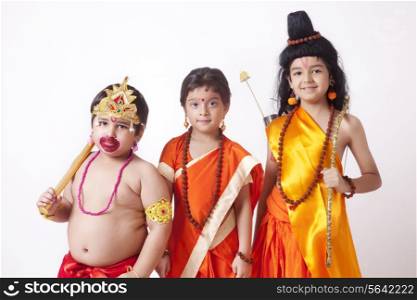 Portrait of children dressed as Hanuman, Sita and Ram against white background