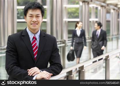 Portrait Of Chinese Businessman Outside Office With Colleagues In Background
