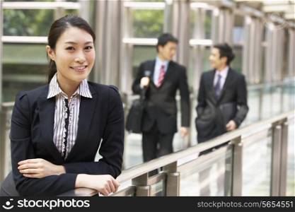 Portrait Of Chinese Businesswoman Outside Office With Colleagues In Background