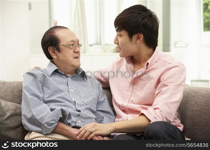 Portrait Of Chinese Father With Adult Son Relaxing At Home