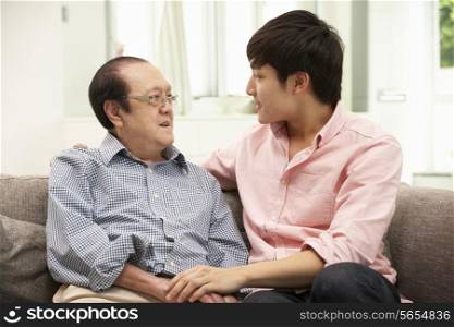 Portrait Of Chinese Father With Adult Son Relaxing At Home