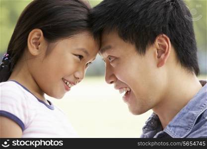 Portrait Of Chinese Father With Daughter Looking At Each Other In Park
