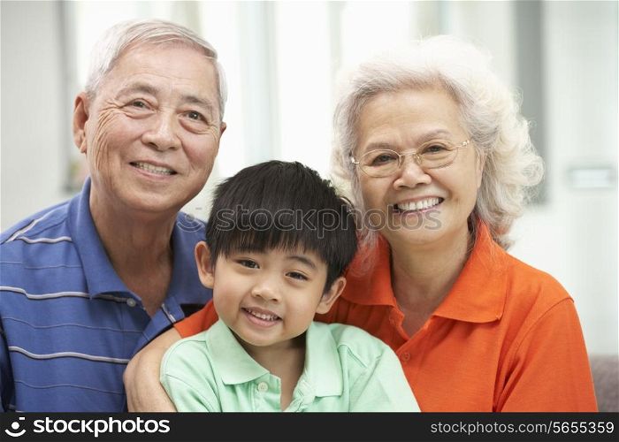 Portrait Of Chinese Grandparents With Grandson Relaxing At Home Together