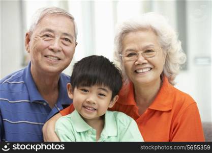 Portrait Of Chinese Grandparents With Grandson Relaxing At Home Together
