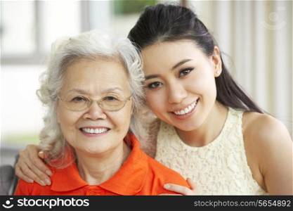 Portrait Of Chinese Mother With Adult Daughter Relaxing At Home