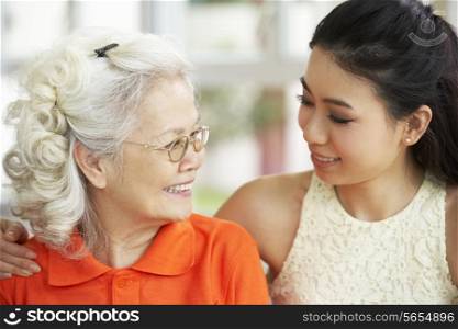 Portrait Of Chinese Mother With Adult Daughter Relaxing At Home