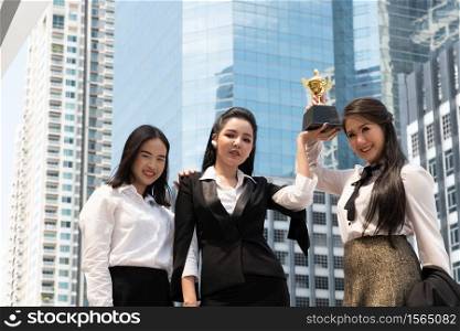 Portrait Of Colleagues With Trophy Standing In City