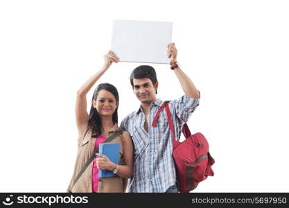 Portrait of college students holding a white board