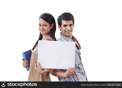 Portrait of college students holding a white board