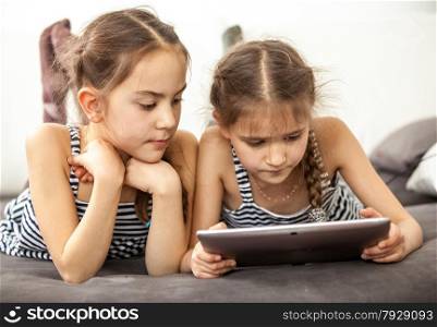 Portrait of concentrated young girls using digital tablet