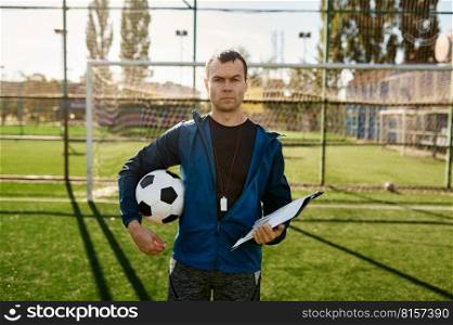 Portrait of confidence serious football coach standing on soccer field and looking at camera. Portrait of confidence serious football coach looking at camera