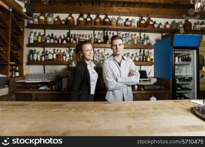 Portrait of confident bartenders at counter in restaurant