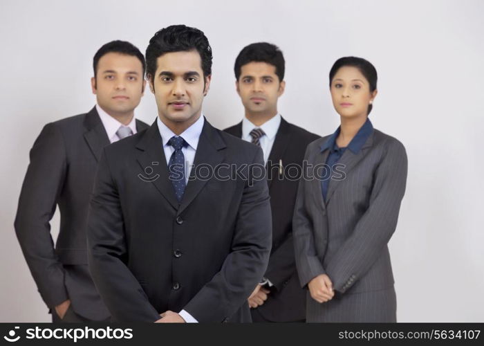 Portrait of confident business people standing against gray background