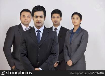 Portrait of confident business people standing against gray background