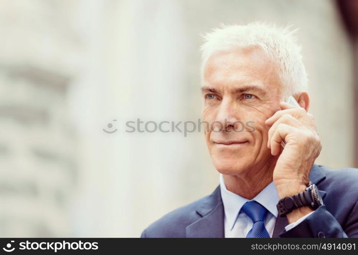 Portrait of confident businessman outdoors. Portrait of confident businessman with his mobile phone outdoors