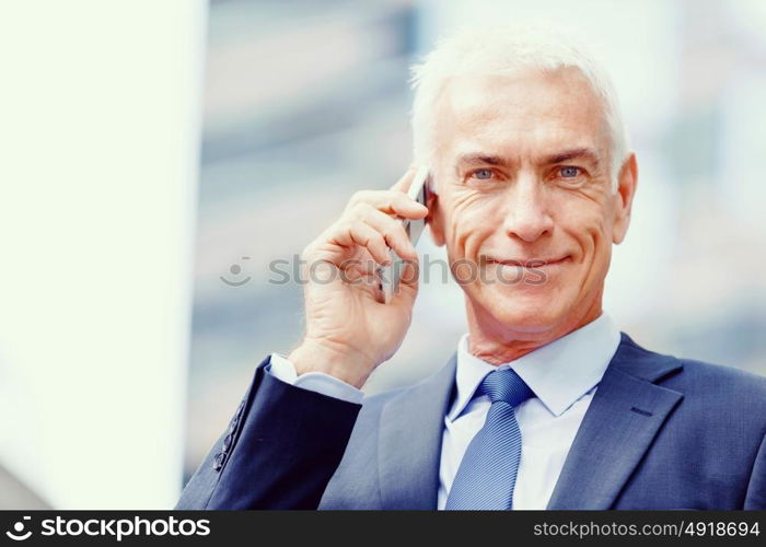 Portrait of confident businessman outdoors. Portrait of confident businessman with his mobile phone outdoors