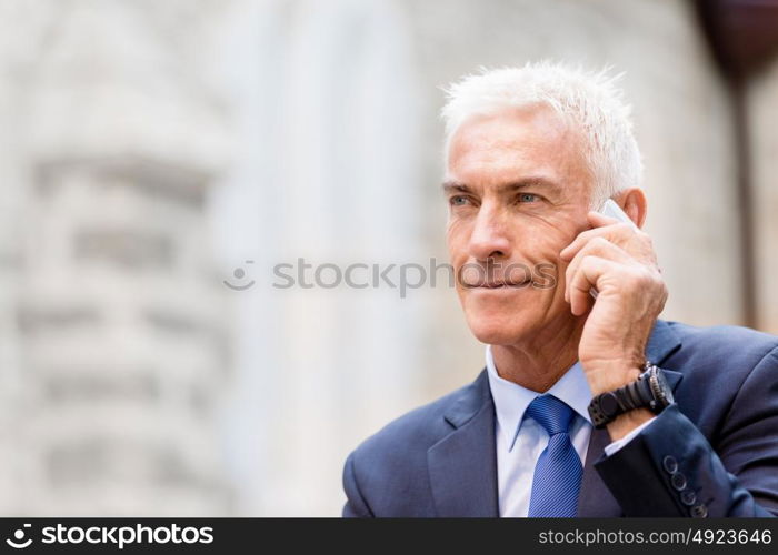 Portrait of confident businessman outdoors. Portrait of confident businessman with his mobile phone outdoors