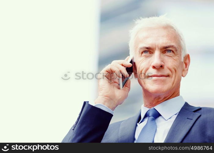 Portrait of confident businessman outdoors. Portrait of confident businessman with his mobile phone outdoors