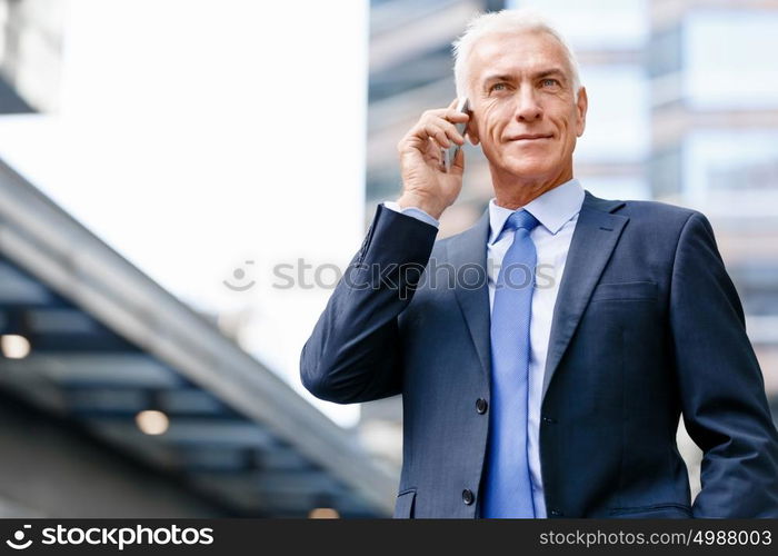 Portrait of confident businessman outdoors. Portrait of confident businessman with his mobile phone outdoors