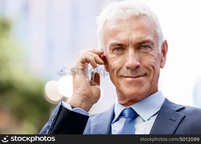 Portrait of confident businessman outdoors. Portrait of confident businessman with his mobile phone outdoors