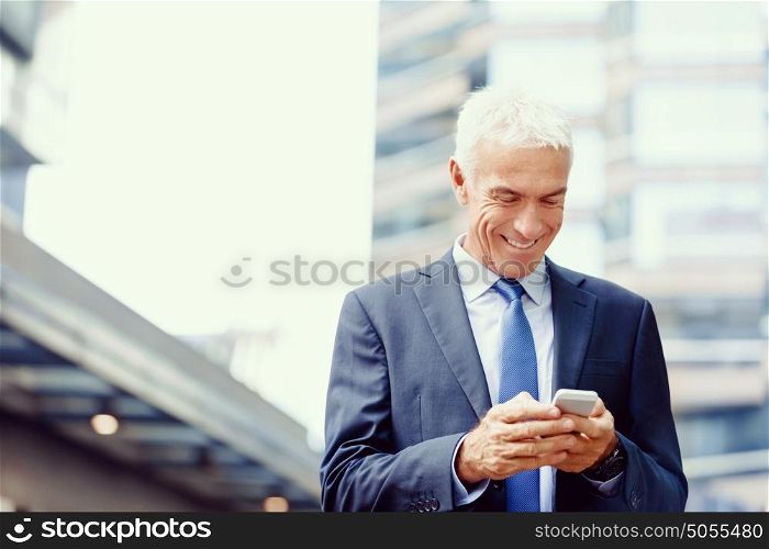 Portrait of confident businessman outdoors. Portrait of confident businessman with his mobile phone outdoors