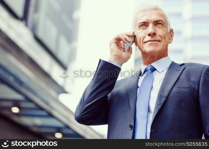 Portrait of confident businessman outdoors. Portrait of confident businessman with his mobile phone outdoors