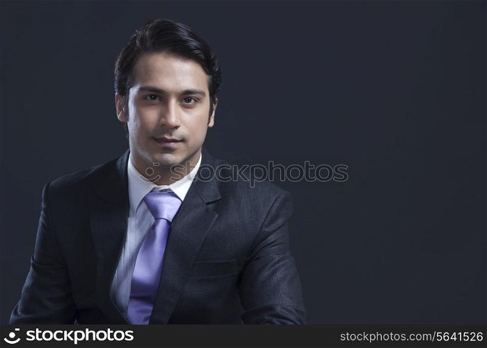 Portrait of confident businessman over black background