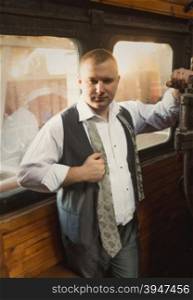Portrait of confident businessman posing in retro train