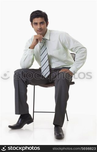 Portrait of confident businessman sitting on chair