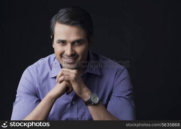 Portrait of confident businessman smiling on black background