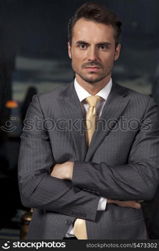 Portrait of confident businessman standing arms crossed in office