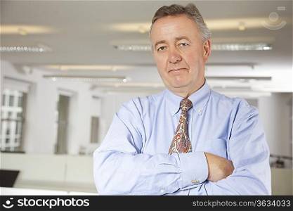 Portrait of confident businessman with arms crossed in office