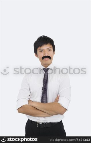 Portrait of confident businessman with fake mustache over white background