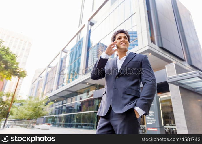 Portrait of confident businessman with mobile phone outdoors. Portrait of confident businessman holding hs mobile phone outdoors