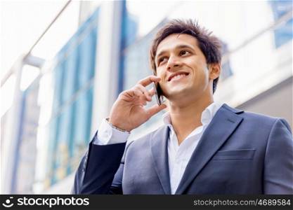 Portrait of confident businessman with mobile phone outdoors. Portrait of confident businessman holding hs mobile phone outdoors