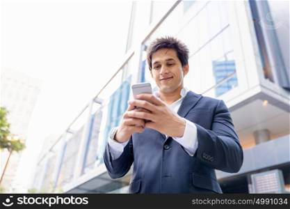 Portrait of confident businessman with mobile phone outdoors. Portrait of confident businessman holding hs mobile phone outdoors
