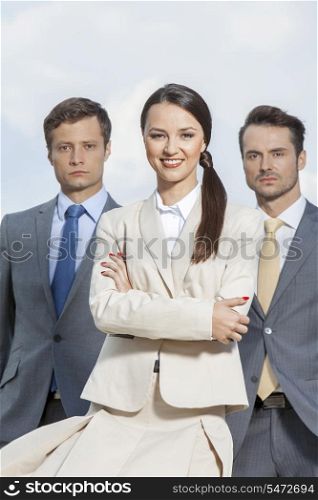 Portrait of confident businesspeople standing together against sky