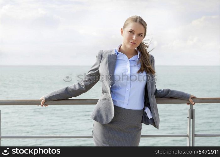 Portrait of confident businesswoman leaning on terrace railings