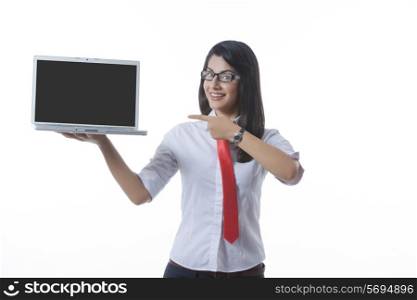 Portrait of confident businesswoman pointing at laptop over white background