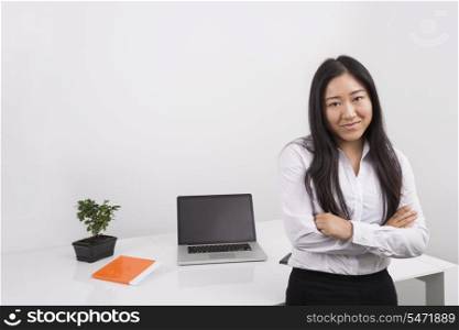 Portrait of confident businesswoman standing arms crossed in office