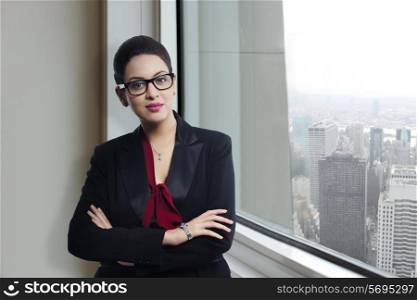 Portrait of confident businesswoman standing by window in office