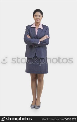 Portrait of confident businesswoman with arms crossed over white background