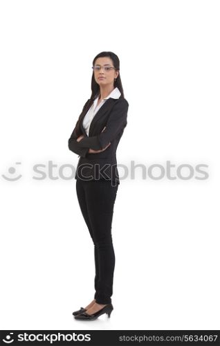 Portrait of confident businesswoman with arms crossed standing against white background