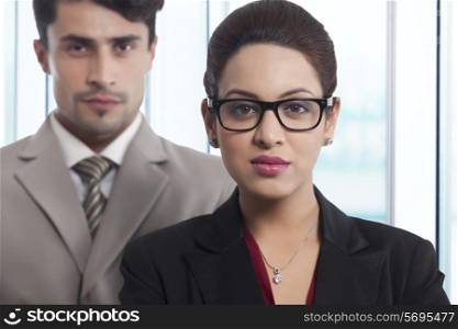 Portrait of confident businesswoman with colleague in office