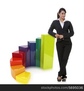 Portrait of confident businesswoman with multi colored bar graph representing growth over white background