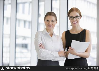 Portrait of confident businesswomen with documents in office