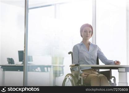 Portrait of confident disabled businesswoman sitting at desk in office