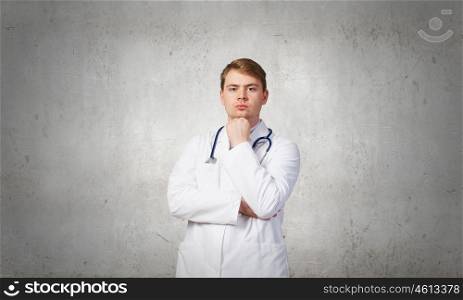 Portrait of confident doctor with arm on chin. Male positive doctor